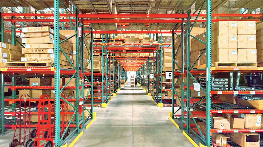 Rows of loaded pallet racking inside a large industrial warehouse