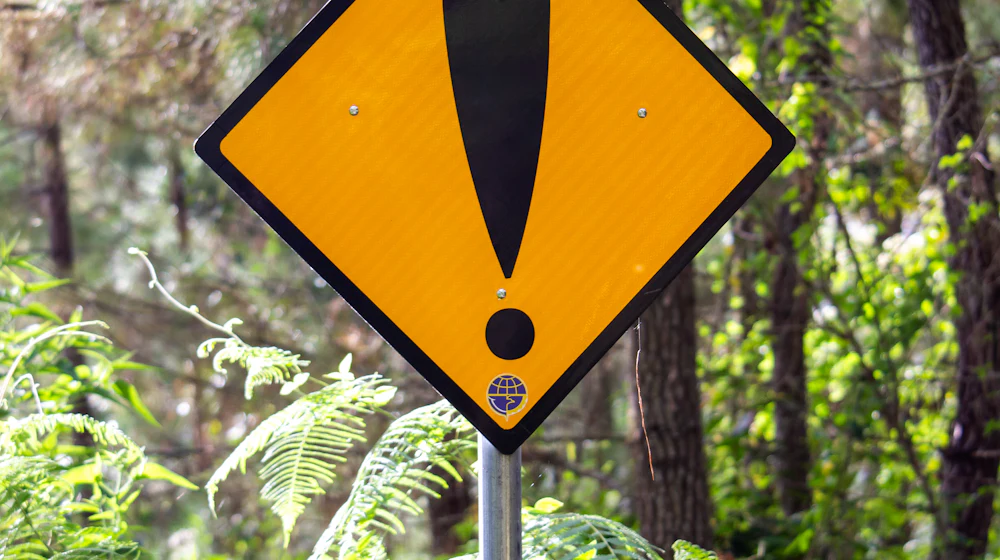 Yellow warning sign with an exclamation mark mounted outdoors