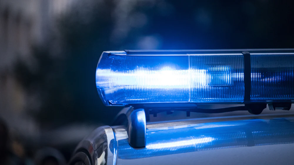 Close-up of a police vehicle light bar flashing blue at night